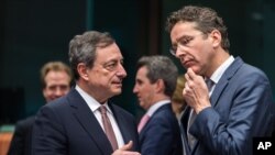 Jeroen Dijsselbloem, pejabat senior Eurozone (kanan) berbicara dengan Gubernur bank sentral Eropa, Mario Draghi di Brussels, Belgia (foto: dok).