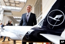 CEO maskapai penerbangan Jerman Lufthansa Carsten Spohr berdiri di samping model Boeing 747 sebelum konferensi pers tahunan di Frankfurt, Jerman, Kamis, 15 Maret 2018. (Michael Probst/AP)