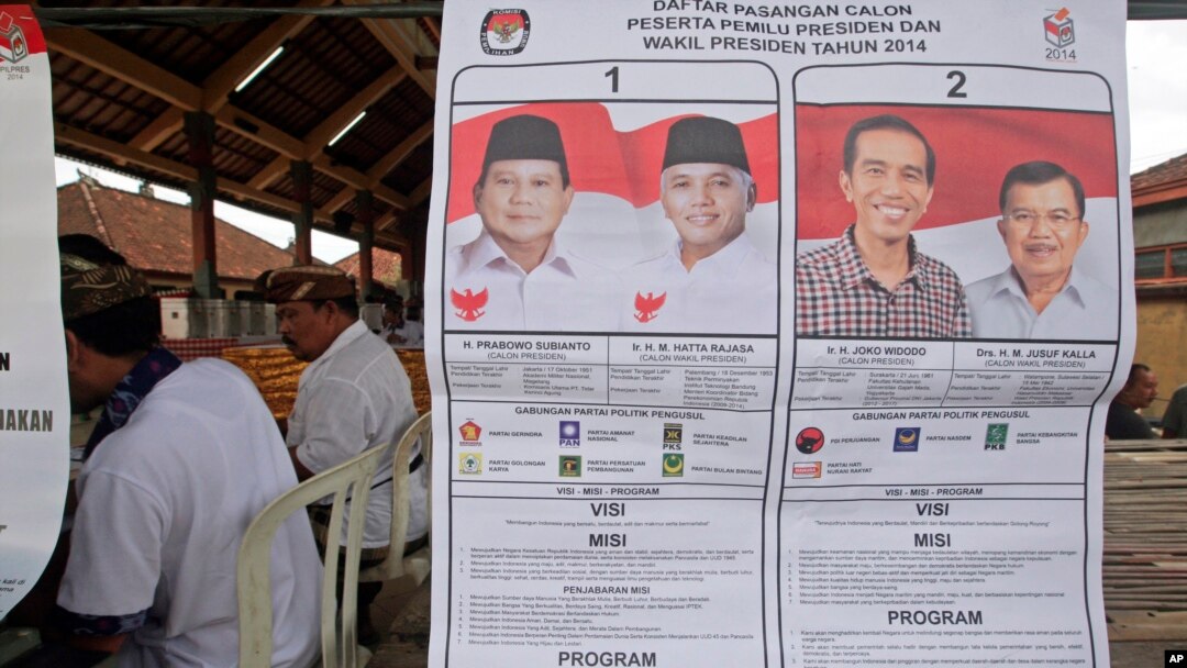 Poster bergambar kedua kandidat presiden dan wakil presiden di sebuah tempat pemungutan suara di Bali (9/7). (AP/Firdia Lisnawati)