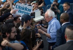 Democratic presidential candidate Sen. Bernie Sanders, I-Vt., signs autographs to Latino supporters at a campaign event at Valley High School in Santa Ana, Calif., Feb. 21, 2020.