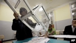 Petugas pemilu Aljazair melakukan perhitungan kartu suara di salah satu TPS di ibukota Algiers (10/5).