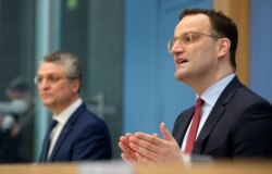 Menteri Kesehatan Jerman Jens Spahn (kanan) dan Lothar H. Wieler (kiri) presiden Robert-Koch-Institute, dalam konferensi pers di Berlin, Jerman, Jumat, 12 Maret 2021. (AP Photo / Michael Sohn)