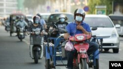 Motorcycle riders wear face masks to curb the spread of COVID-19 in Phnom Penh, Cambodia. (Hean Socheata/VOA Khmer)