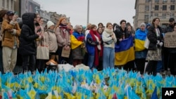 Un grupo de personas se concentran en el sitio conmemorativo de aquellos que perdieron la vida durante la guerra, cerca de la Plaza Maidan en el centro de Kiev, Ucrania, el 24 de febrero de 2024.