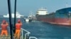 In this photo made from video released by the Taiwan Coast Guard, Taiwanese Coast Guard vessels prepare to board Togolese-flagged cargo ship Hongtai suspected of severing an undersea communications cable, Feb 25, 2025. 