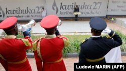 Le président français Emmanuel Macron dépose une gerbe lors d'une visite au Mémorial du génocide de Kigali, où sont enterrées quelque 250 000 victimes des massacres, à Kigali, le 27 mai 2021.