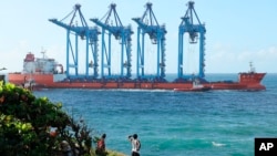 FILE - A vessel carries four cranes to be off-loaded at the port of Mombasa through the Kilindini channel, Kenya, on Aug. 7, 2023. Africa has seen significant growth in its port capacity in the past decade.