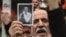 A man holds a picture of Selahattin Demirtas as people gather outside Bakirkoy courthouse in Istanbul, Jan. 12, 2018, in support of the jailed co-chair of the People's Democratic Party (HDP). 