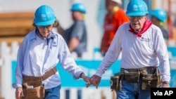 FILE - Former President Jimmy Carter holds hands with his wife Rosalynn Carter as they work with other volunteers for Habitat for Humanity in Mishawaka, Indiana, Aug. 27, 2018. (Robert Franklin/South Bend Tribune)