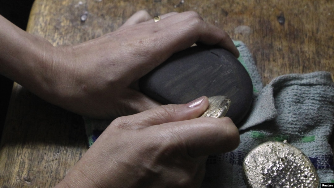 Pedagang emas memakai batu untuk menilai tingkat dan harga bongkahan emas di Diwalwal, Filipina Selatan.(Foto: Reuters)