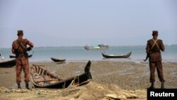 FILE - Members of Border Guard Bangladesh (BGB) stand guard on the bank of Naf River near the Bangladesh-Myanmar border to prevent Rohingya refugees from illegal border crossing, in Teknaf near Cox’s Bazar, Bangladesh, Nov. 22, 2016. 