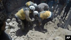 This photo provided by the Syrian Civil Defense White Helmets, which has been authenticated based on its contents and other AP reporting, shows Syrian White Helmet civil defense workers pull out a victim from under the rubble of a destroyed building…