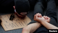 Para pengunjuk rasa berpose seperti sedang diamankan dalam unjuk rasa memprotes kematian George Floyd, di Boston, Massachusetts, 4 Juni 2020. (Foto: Reuters)