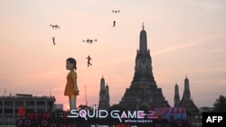  ကမ္ဘာကျော် Squid Game တောင်ကိုရီးယား တီဗွီစီးရီးစ်ထဲက ဇာတ်ရုပ် ၁၂ မီတာ (၃၉ ပေကျော်) အမြင့်ရှိတဲ့ ယောင်ဟီးအရုပ်ကို ထိုင်းနိုင်ငံ ကျောက်ဖရားမြစ်ထဲမှာ ကြော်ငြာသရုပ်ပြလှည့်လည်နေစဥ်။ (ဒီဇင်ဘာ ၁၉၊ ၂၀၂၄) 