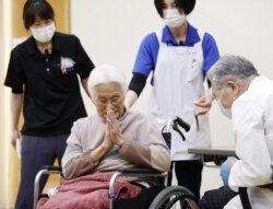 Seorang perempuan lanjut usia memberikan isyarat untuk mengucapkan terima kasih setelah menerima vaksinasi COVID-19 di Itami, Jepang barat, 12 April 2021. (Foto: Kyodo via Reuters)