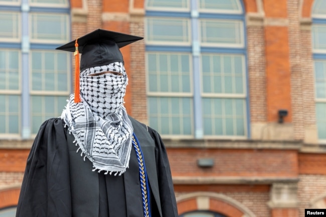 A Palestinian student, who plans to return to his homeland after graduation and who wishes to remain anonymous, poses for a portrait while wearing a keffiyeh along with his commencement cap at the Auraria Campus in Denver, Colorado, U.S., May 10, 2024. (REUTERS/Kevin Mohatt)