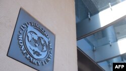 (FILES) In this file photo taken on April 15, 2020 a sign is seen outside the headquarters of the International Monetary Fund (IMF) as the IMF and World Bank hold their Spring Meetings virtually due to the outbreak of COVID-19, known as coronavirus, in…