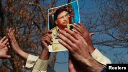 FILE - A supporter holds a picture of former Pakistani President Pervez Musharraf, during a protest with others at the Special Court where Musharraf will attend his trial in Islamabad, Feb. 18, 2014. 