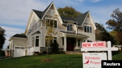 FILE - A real estate sign advertising a new home for sale is pictured in Vienna, Virginia, outside of Washington, Oct. 20, 2014. 