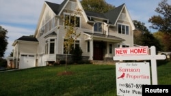 FILE - A real estate sign advertising a new home for sale is pictured in Vienna, Virginia, outside of Washington, Oct. 20, 2014. 
