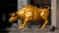 FILE - A homeless person sleeps next to the Golden Bull, a replica of Wall street Charging Bull symbolizing the financial market, outside the Brazilian B3 Stock Exchange in Sao Paulo, Brazil, Nov. 17, 2021. 