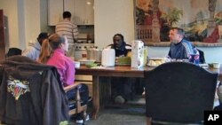 Rob Farley, a Washington Attorney and church member of a congregation, sits at the table with others. He starts early each day offering coffee and breakfast to the city homeless