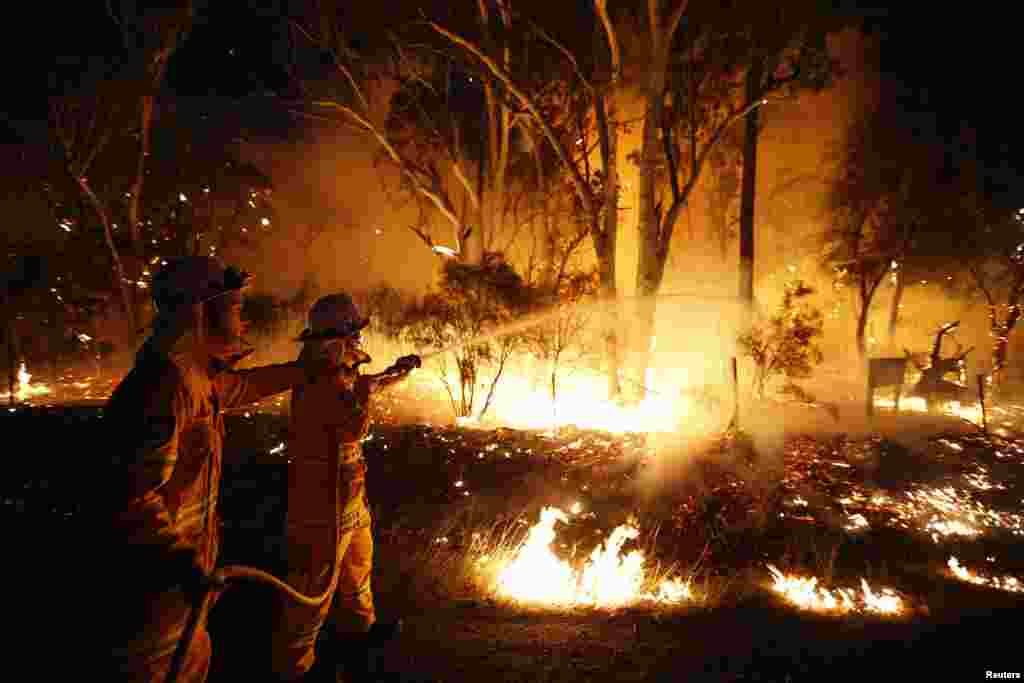 Para petugas pemadam kebakaran berupaya memadamkan kebakaran hutan di hutan lindung Windsor Downs, dekat Sydney (10/9). (Reuters/Daniel Munoz)