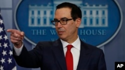 Treasury Secretary Steven Mnuchin points to a reporter to take a question during the news briefing at the White House, in Washington, Aug. 25, 2017. 