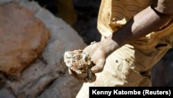 An artisanal miner carries raw ore at Tilwizembe, a former industrial copper-cobalt mine, outside of Kolwezi, the capital city of Lualaba Province in the south of the Democratic Republic of the Congo, June 11, 2016. 