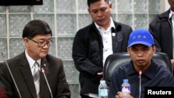 Jerry Umlang (R) answers questions from the members of the media regarding his alleged involvement in the kidnapping and murder of South Korean businessman Jee Ick-Joo while Department of Justice Secretary Vitaliano Aguirre (L) looks on during a press bri