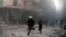 Emergency responders rush following a reported barrel bomb attack by government forces in the Al-Muasalat area in the northern Syrian city of Aleppo, Nov. 6, 2014. 