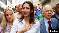 María Corina Machado habla con los reporteros junto a Lilian Tintori al llegar a la fiscalía en Caracas.