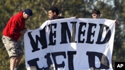 Detainees hold a protest sign atop a building at Villawood detention centre in Sydney, April 21, 2011.