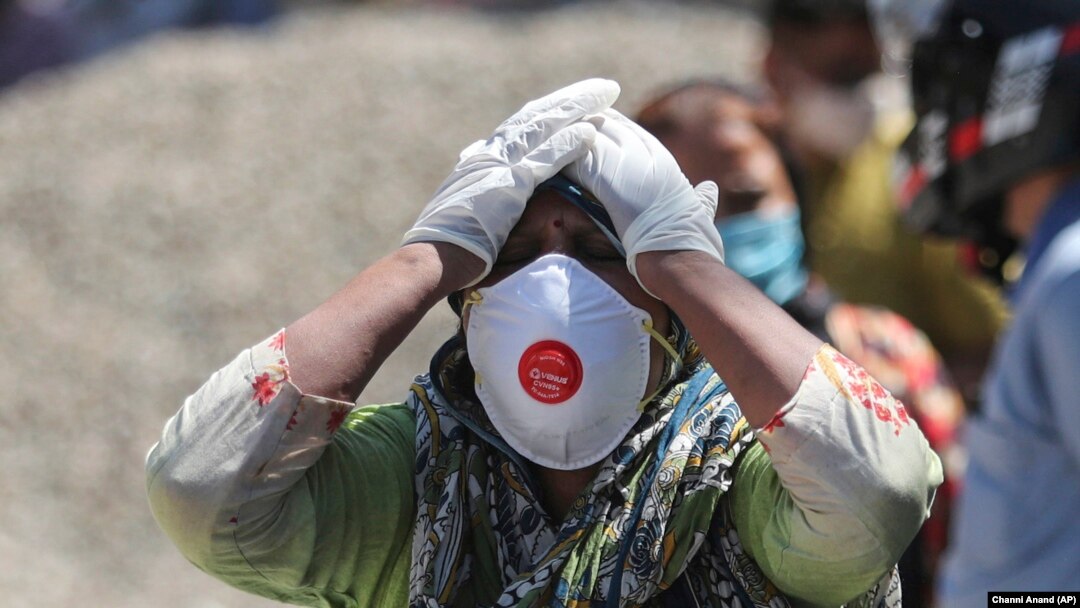 Reaksi seorang kerabat dari pasien COVID-19 yang meninggal di krematorium di Jammu, India, Minggu, 25 April 2021. (Foto: Channi Anand/AP)