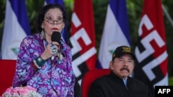 Imagen del folleto difundido por la presidencia nicaragüense que muestra al presidente Daniel Ortega (der.) escuchando a su esposa y vicepresidenta Rosario Murillo pronunciando un discurso, en la Plaza de la Revolución, el 2 de septiembre de 2020. 