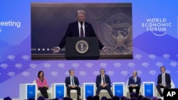 La gente sigue un discurso virtual del presidente estadounidense Donald Trump en la Reunión Anual del Foro Económico Mundial en Davos, Suiza, el jueves 23 de enero de 2025. (Foto AP/Markus Schreiber)