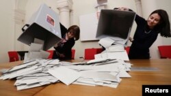 Election committee members are seen as they count votes after polling stations closed for the country's direct presidential election, in Prague, the Czech Republic, Jan. 13, 2018. 