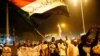 Sudanese people chant slogans and wave Sudanese flags during a demonstration in Khartoum.