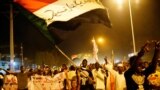 Sudanese people chant slogans and wave Sudanese flags during a demonstration in Khartoum.