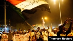 Sudanese people chant slogans and wave Sudanese flags during a demonstration in Khartoum.