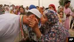 Seorang jemaah haji dari Srinagar, Kashmir, mendapat ciuman perpisahan dari kerabatnya sebelum pergi naik haji (10/8). (AP/Mukhtar Khan)