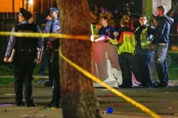 FILE - Emergency personnel work at the scene after a person was run over and killed by a float during The Mystic Krewe of Nyx Mardi Gras parade in New Orleans, Feb. 19, 2020.