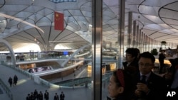 ARCHIVO - Visitantes pasan por el Aeropuerto Internacional Daxing de Beijing, China, el 11 de diciembre de 2019.