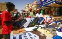 A street vendor displays shirts at a market in the Sudanese capital Khartoum on Feb. 21, 2021.