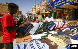 A street vendor displays shirts at a market in the Sudanese capital Khartoum on Feb. 21, 2021.