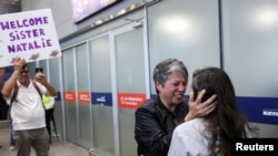 Claudia Díaz sostiene el rostro de su hermana Natalie, una de las víctimas de adopciones forzadas de la era de Pinochet, en el aeropuerto de Santiago de Chile el 22 de febrero de 2025