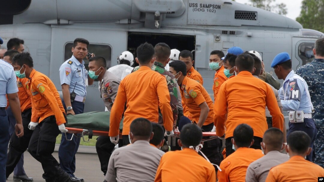 Tim SAR dan polisi Indonesia membawa jenasah korban AirAsia yang dikeluarkan dari helikopter Angkatan Laut USS Sampson di pelabuhan Pangkalan Bun (2/1/2015).