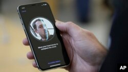 An Apple employee demonstrates the facial recognition feature of the new iPhone X at the Apple Union Square store in San Francisco. 