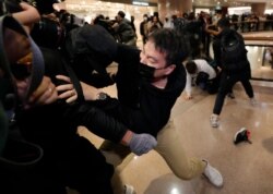 Plain clothed police officers arrest protesters in a mall during Christmas Eve in Hong Kong, Dec. 24, 2019.
