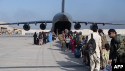 乘客在哈米德·卡爾扎伊國際機場登上美國空軍的C-17運輸機。(2021年8月24日)